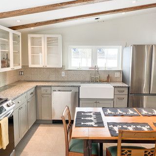 A kitchen with a table and chairs and a sink.