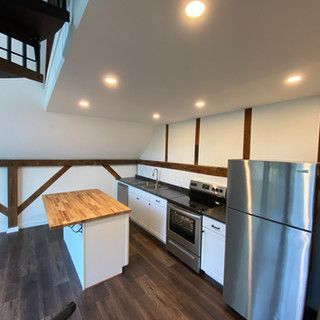 A kitchen with stainless steel appliances and a wooden table.