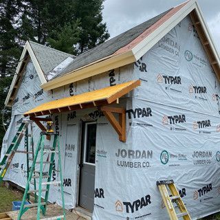 A house is being remodeled with a canopy and a ladder.