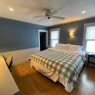 A bedroom with a king size bed and a ceiling fan.