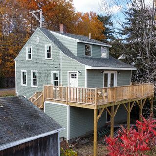 An aerial view of a house with a large deck surrounded by trees.