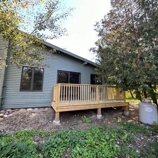 A small house with a wooden deck in front of it.