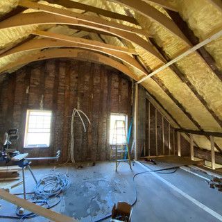 There is a ladder in the attic of a house under construction.