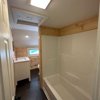 A bathroom with a tub , sink , and shower.
