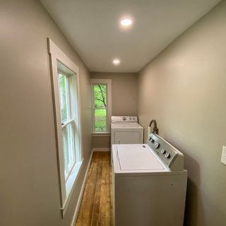 A laundry room with a washer and dryer and a window.