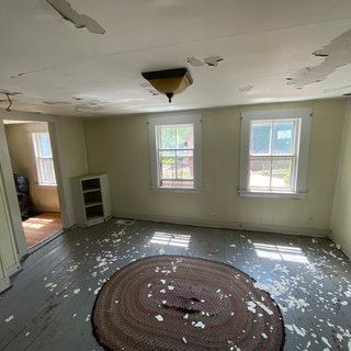 An empty room with a rug on the floor and a ceiling light.