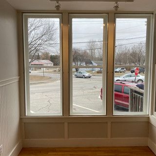 A room with a lot of windows and a view of a street.