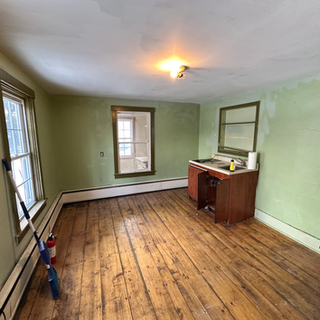 An empty room with wooden floors and green walls