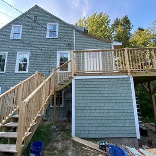 A house with a deck and stairs on the side of it.