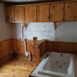 A bathroom with a jacuzzi tub and wooden cabinets.