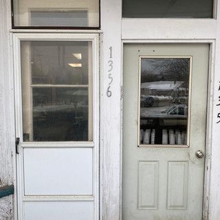 A white door with a window on the side of a building.