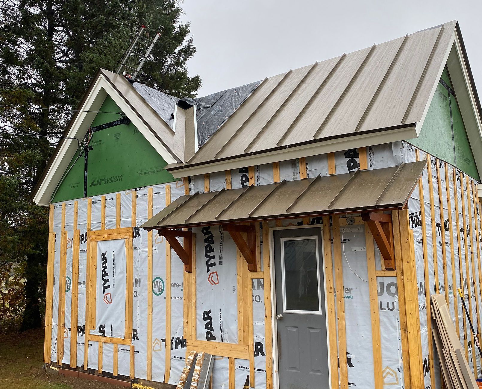 A small house with a metal roof is being built.