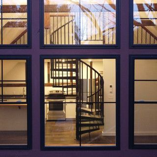 A spiral staircase is visible through the windows of a house