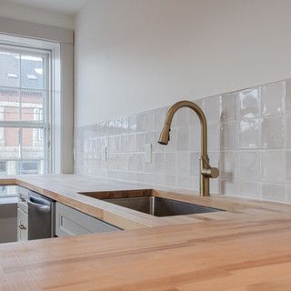 A kitchen with a sink and a wooden counter top.