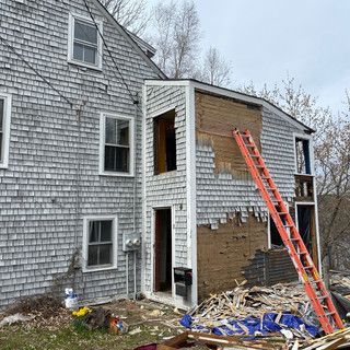 A ladder is sitting in front of a house that is being demolished.