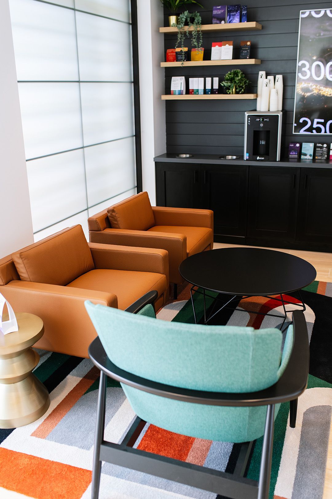 A living room with chairs , a table and a coffee maker.