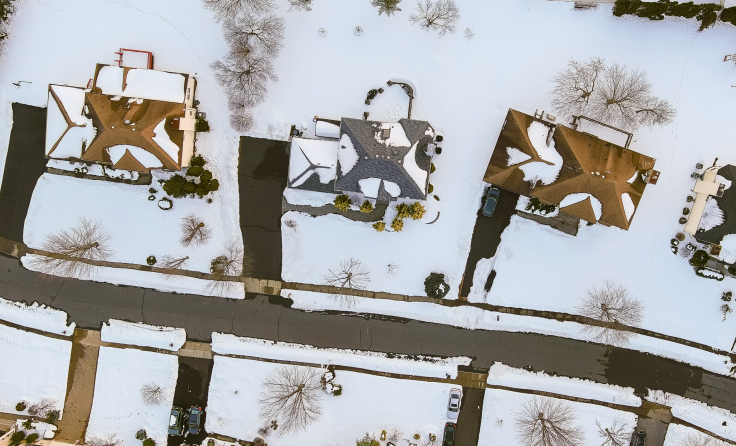 An aerial view of snowy houses.