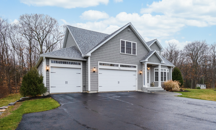 A large house with two garage doors and a driveway