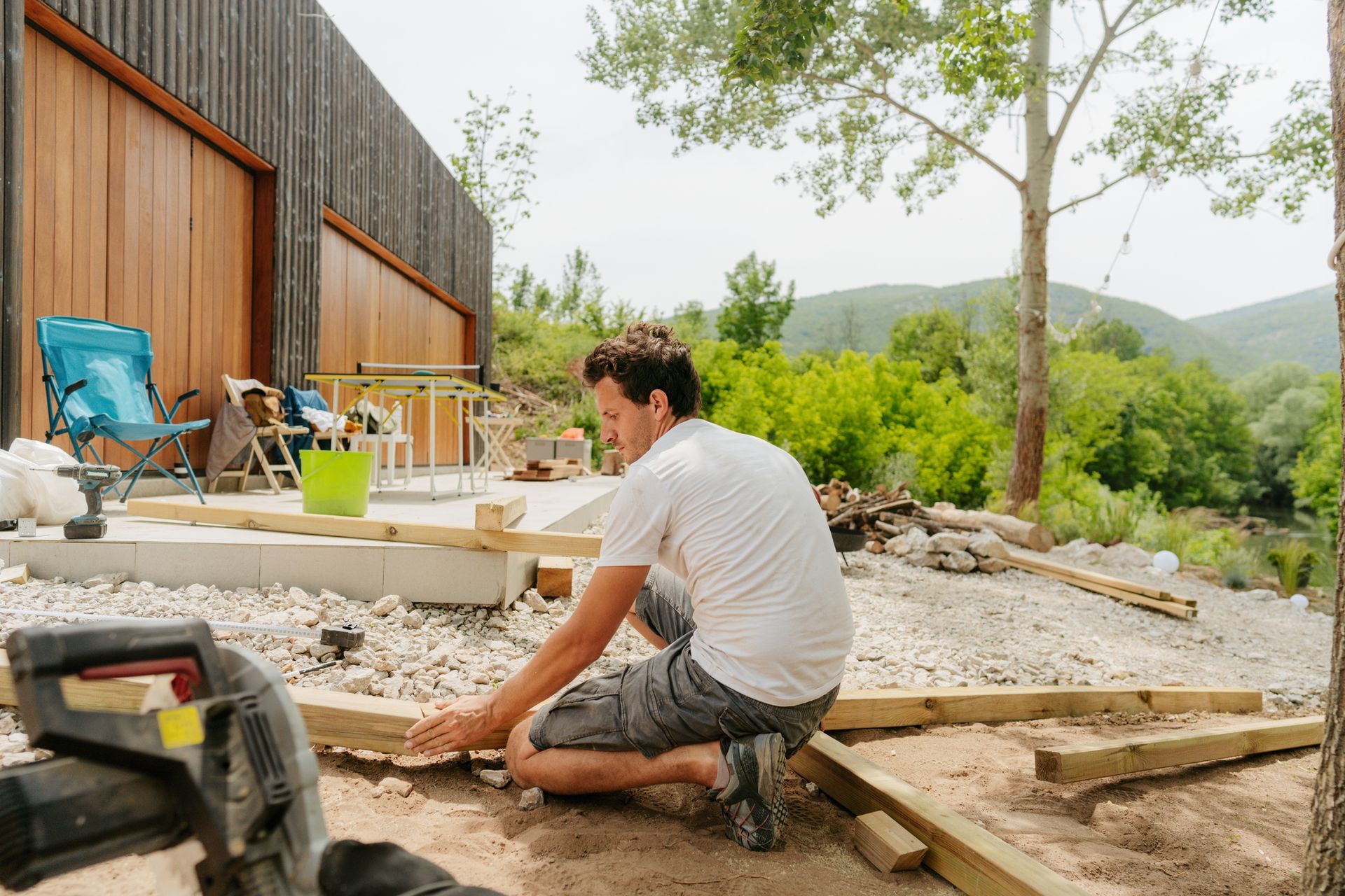 Outdoor living contractors building a wooden house in a serene forest environment.