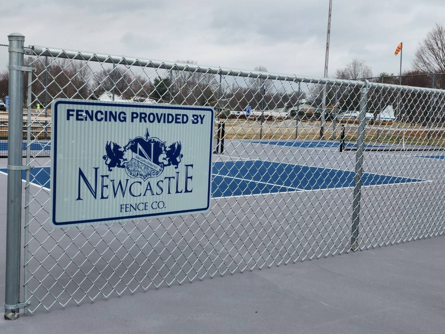 A sign on a chain-link fence at a Newcastle park. The sign reads: 