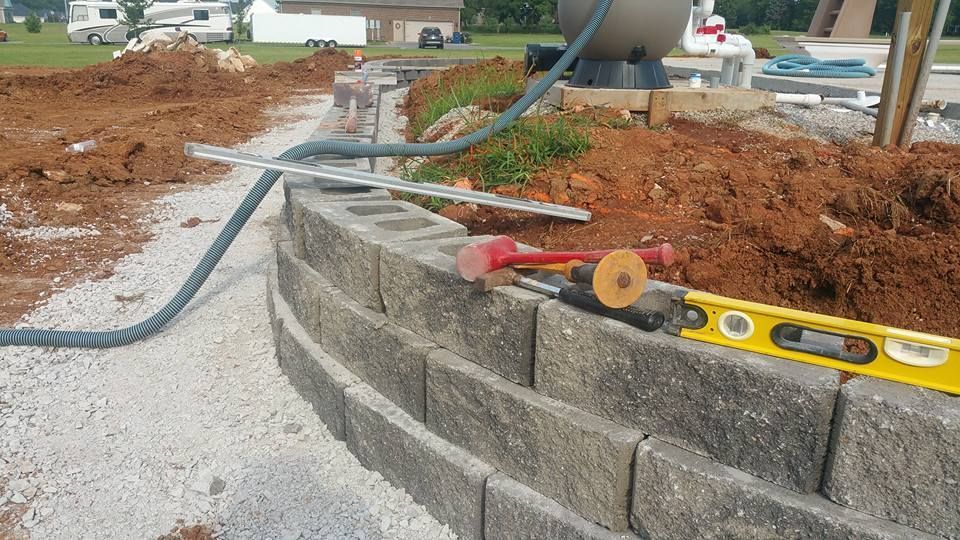 A yellow level is sitting on top of a brick wall.