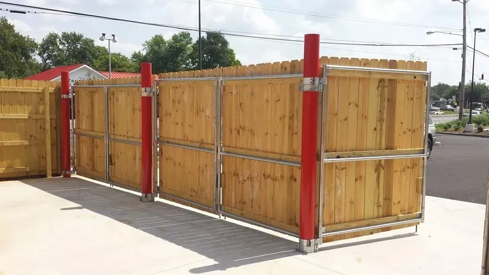 A wooden fence with a red pole in the middle of it.