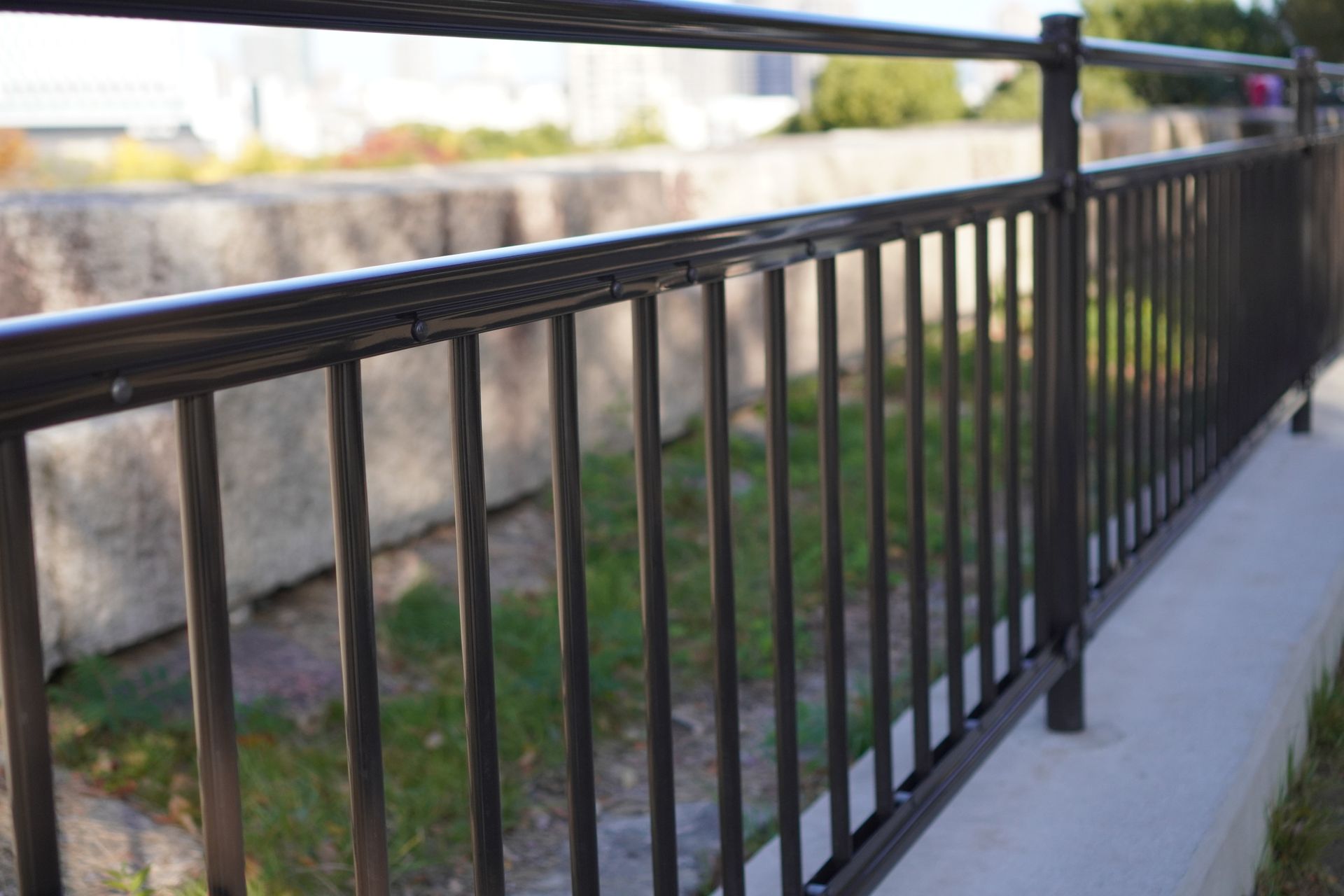 Two men are working on a fence with a hammer drill.