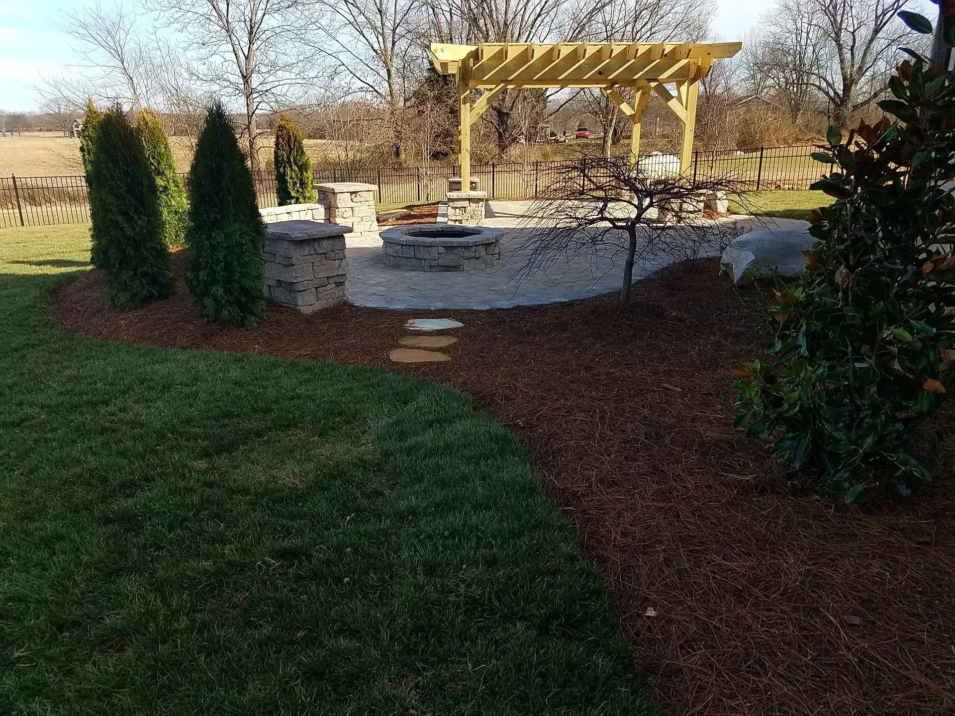 There is a pergola in the middle of the backyard.
