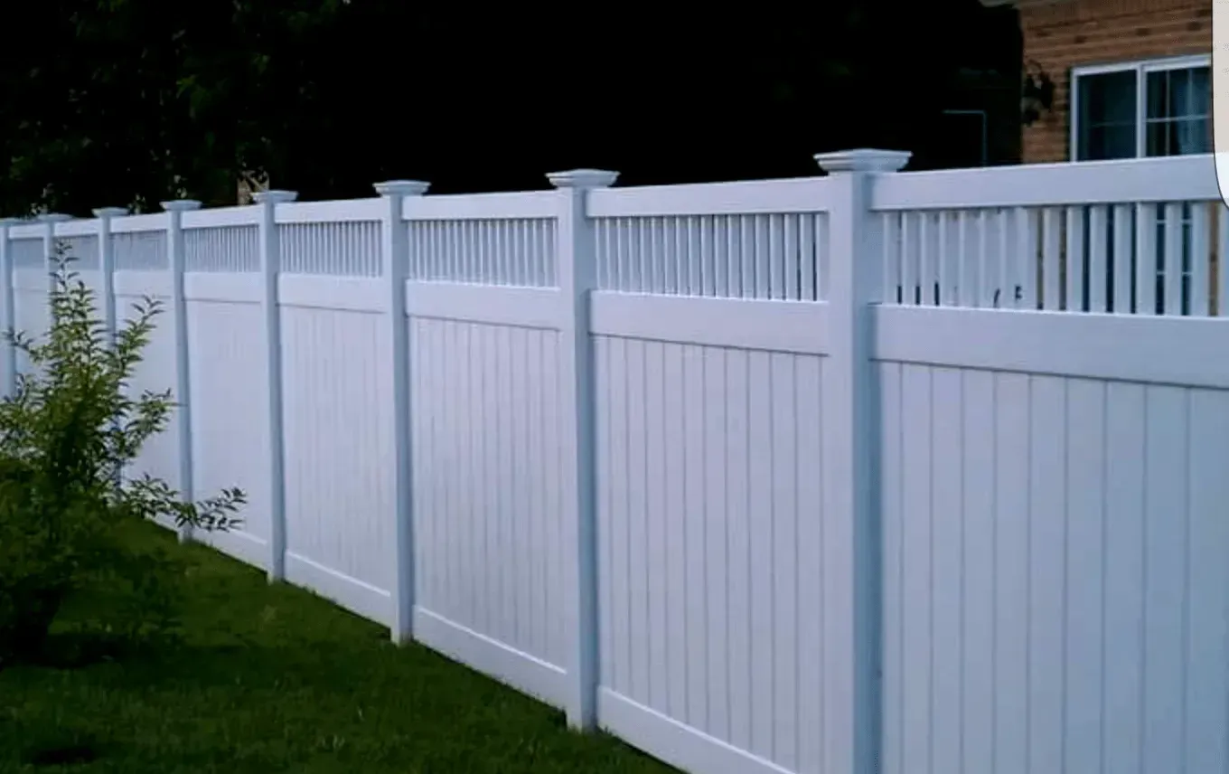 White vinyl fence in a grassy yard.