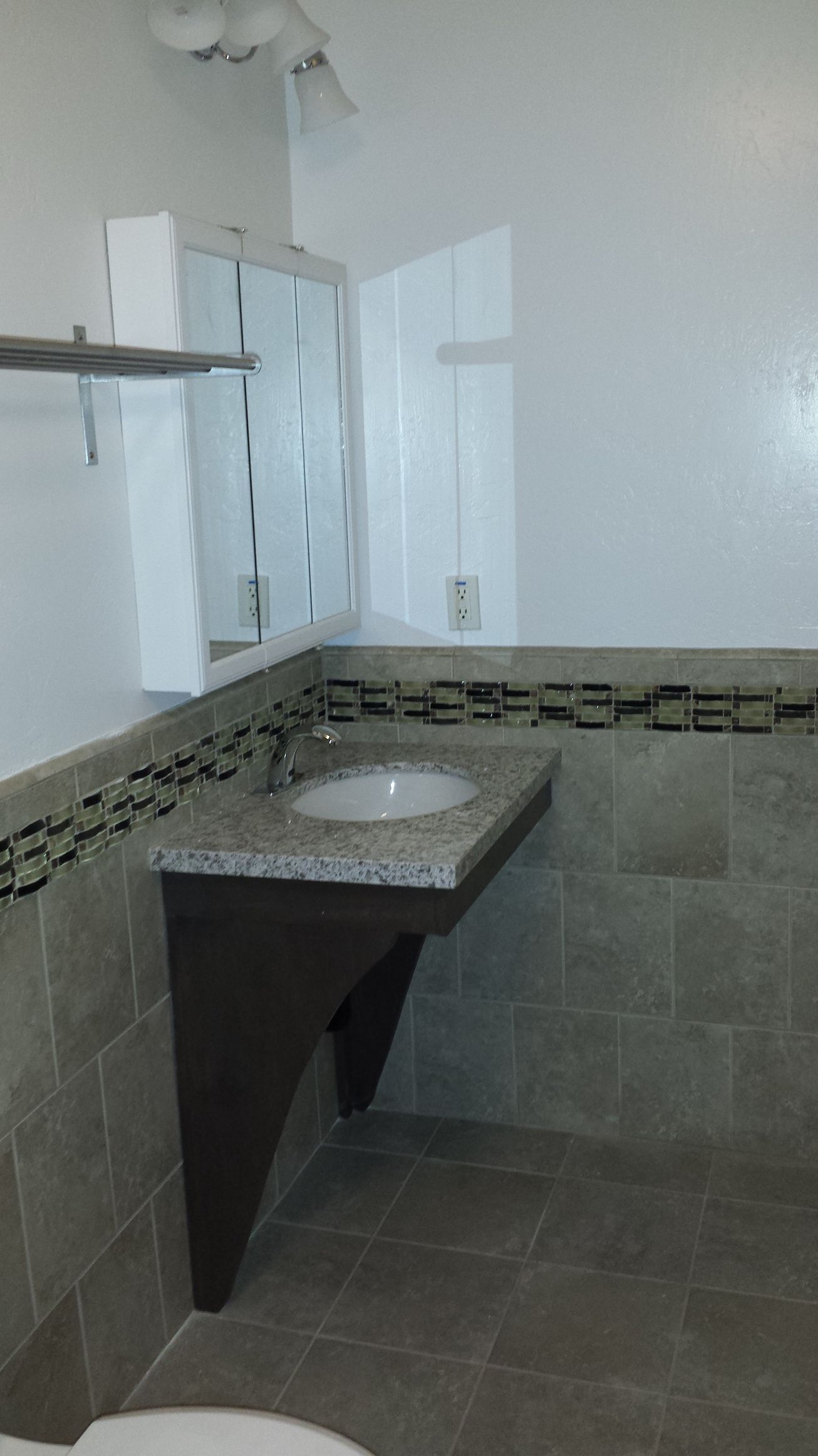 A bathroom with a sink , toilet and mirror.