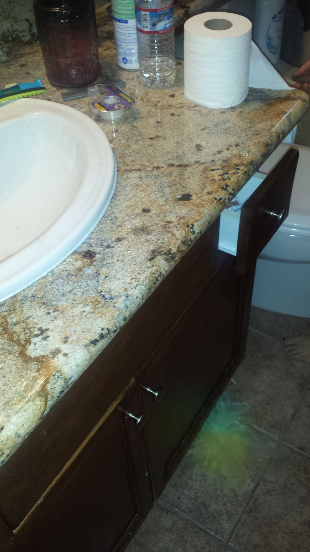 A bathroom counter with a roll of toilet paper on it.