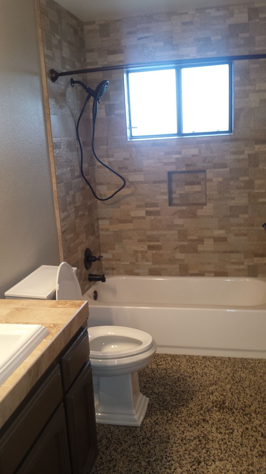 A bathroom with a toilet , bathtub and shower.