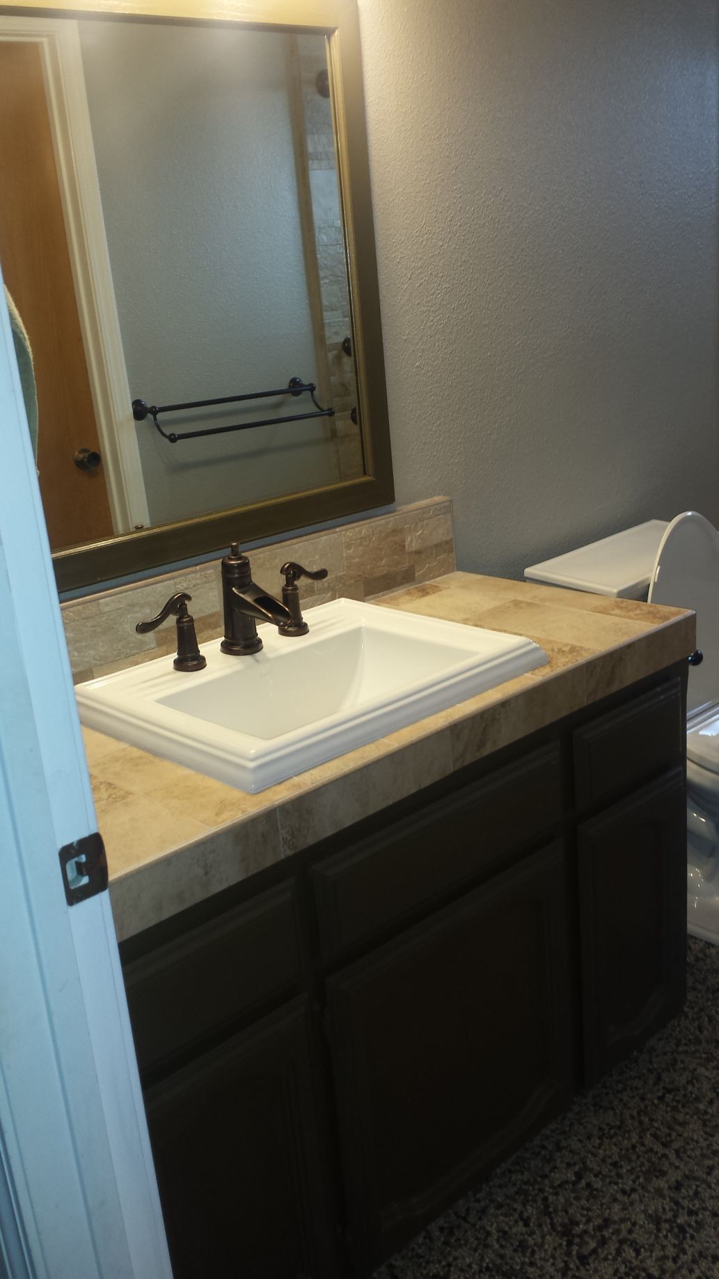 A bathroom with a sink , toilet and mirror.