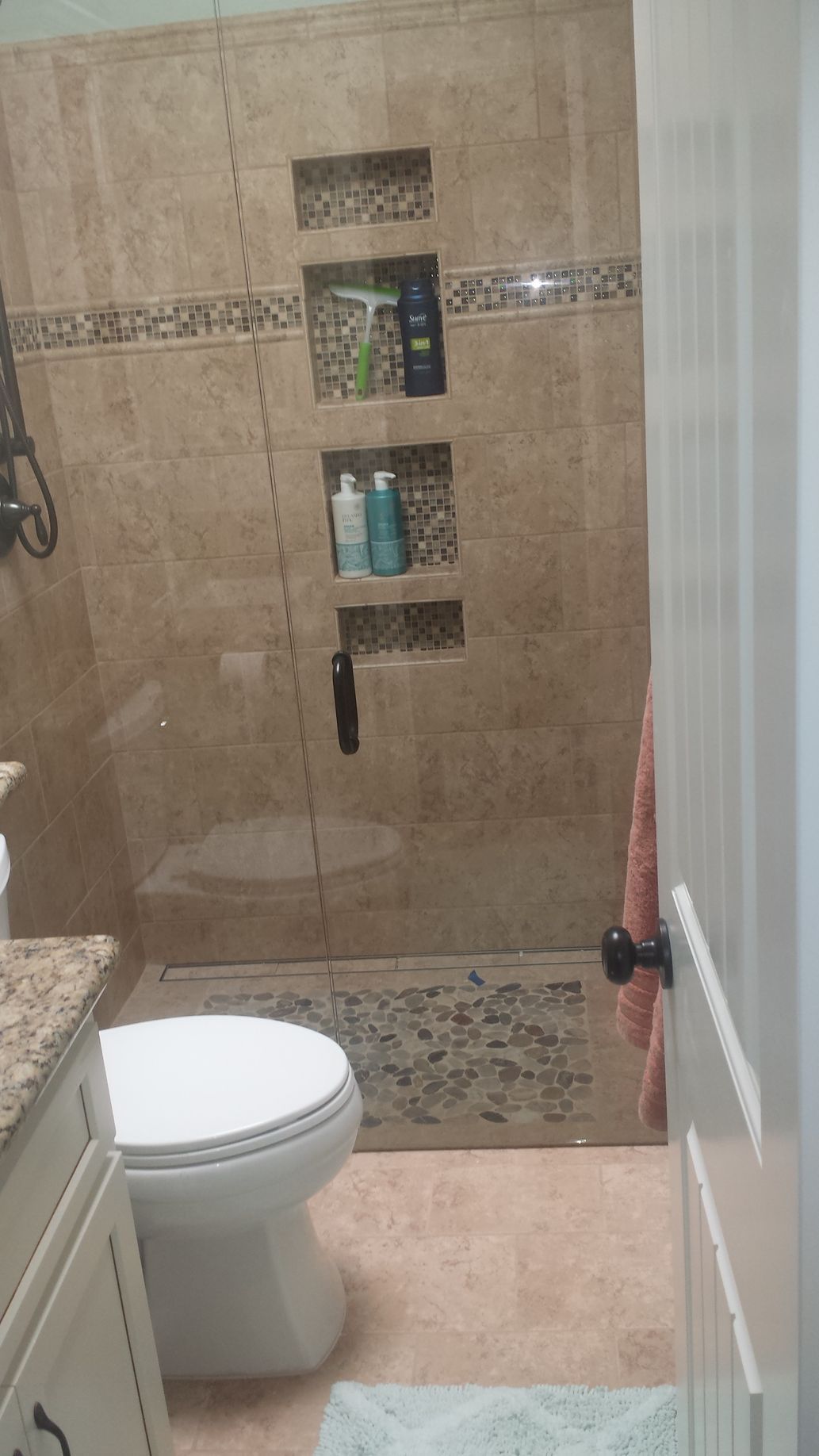 A bathroom with a toilet and a walk in shower.