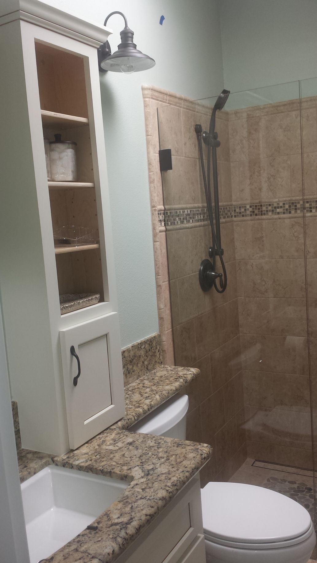 A bathroom with a toilet , sink , and shower.