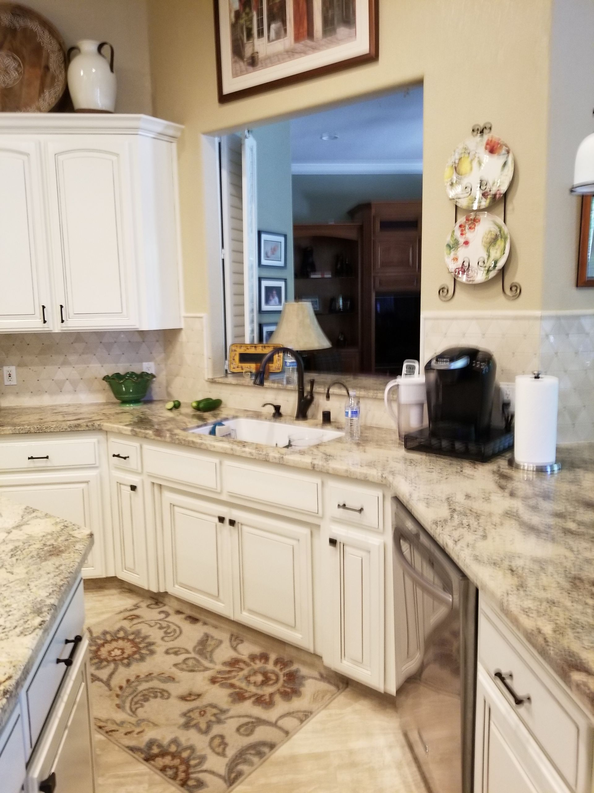 A kitchen with white cabinets and granite counter tops