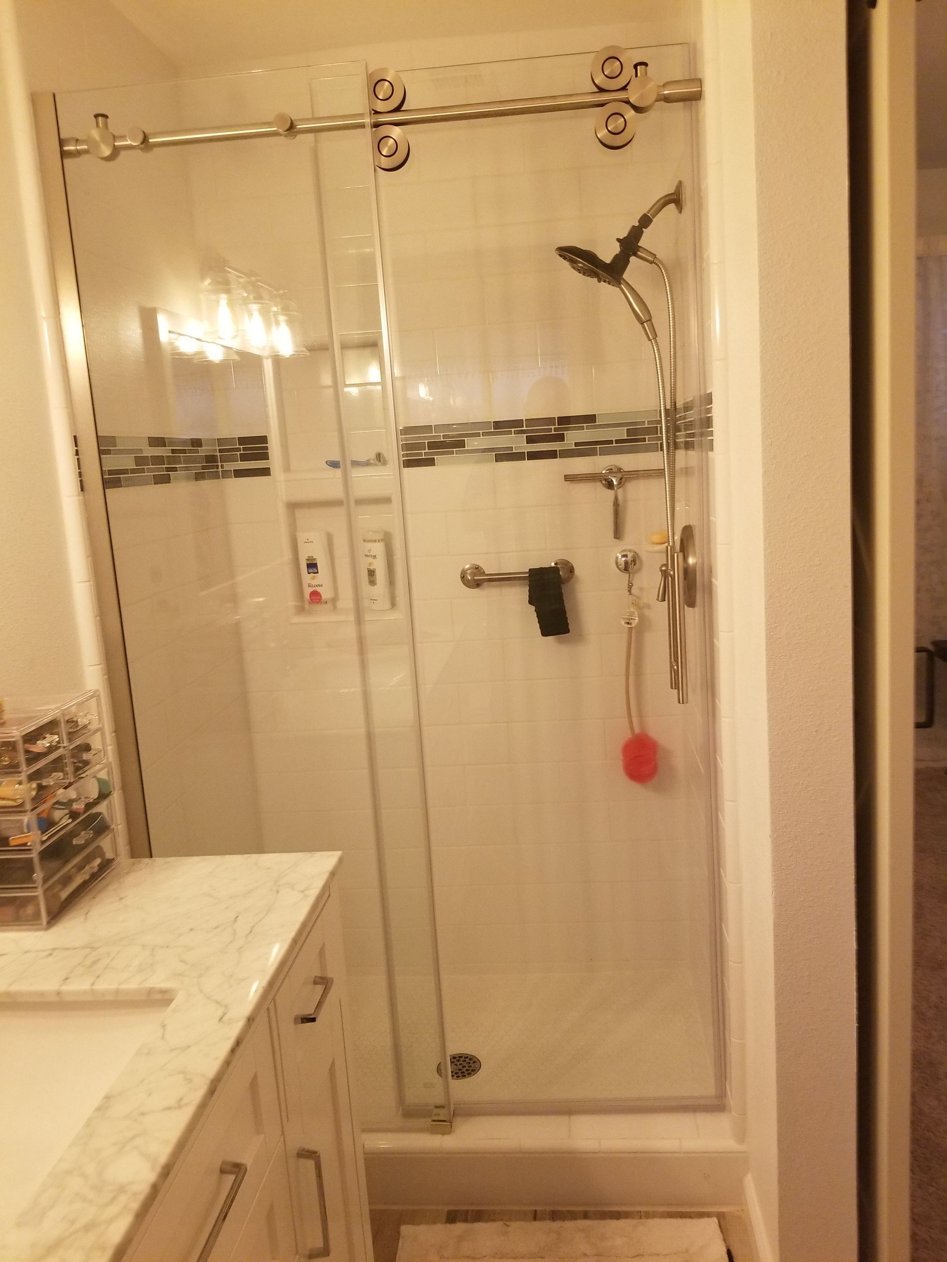 A bathroom with a sliding glass shower door