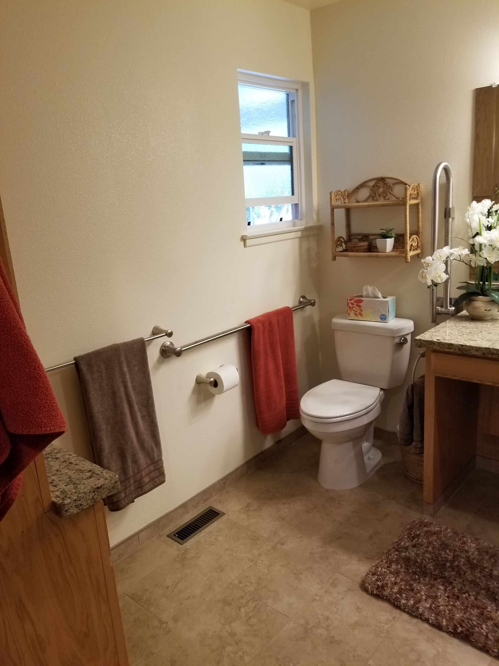 A bathroom with a toilet , sink , and window