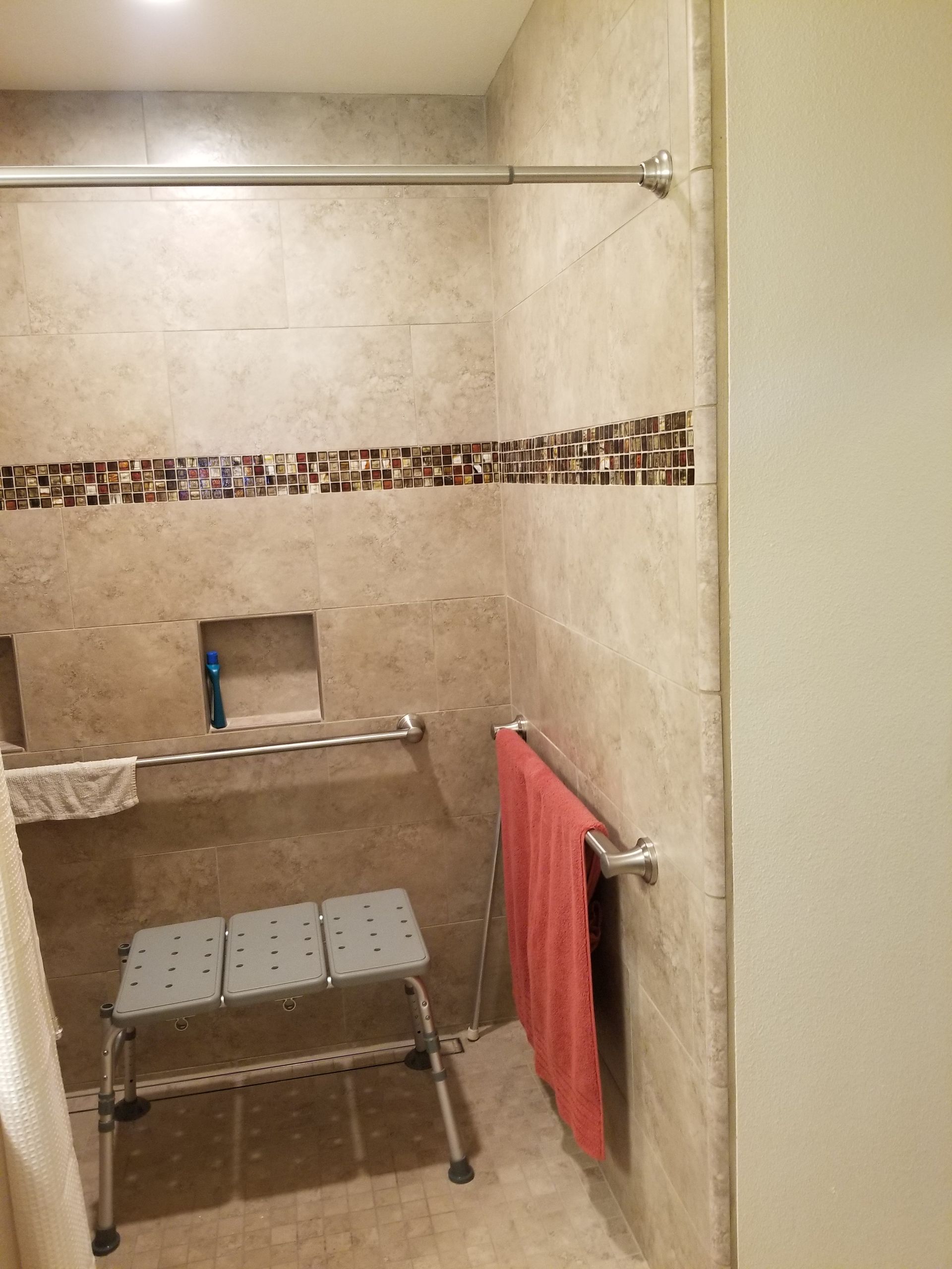 A bathroom with a stool and a towel rack.