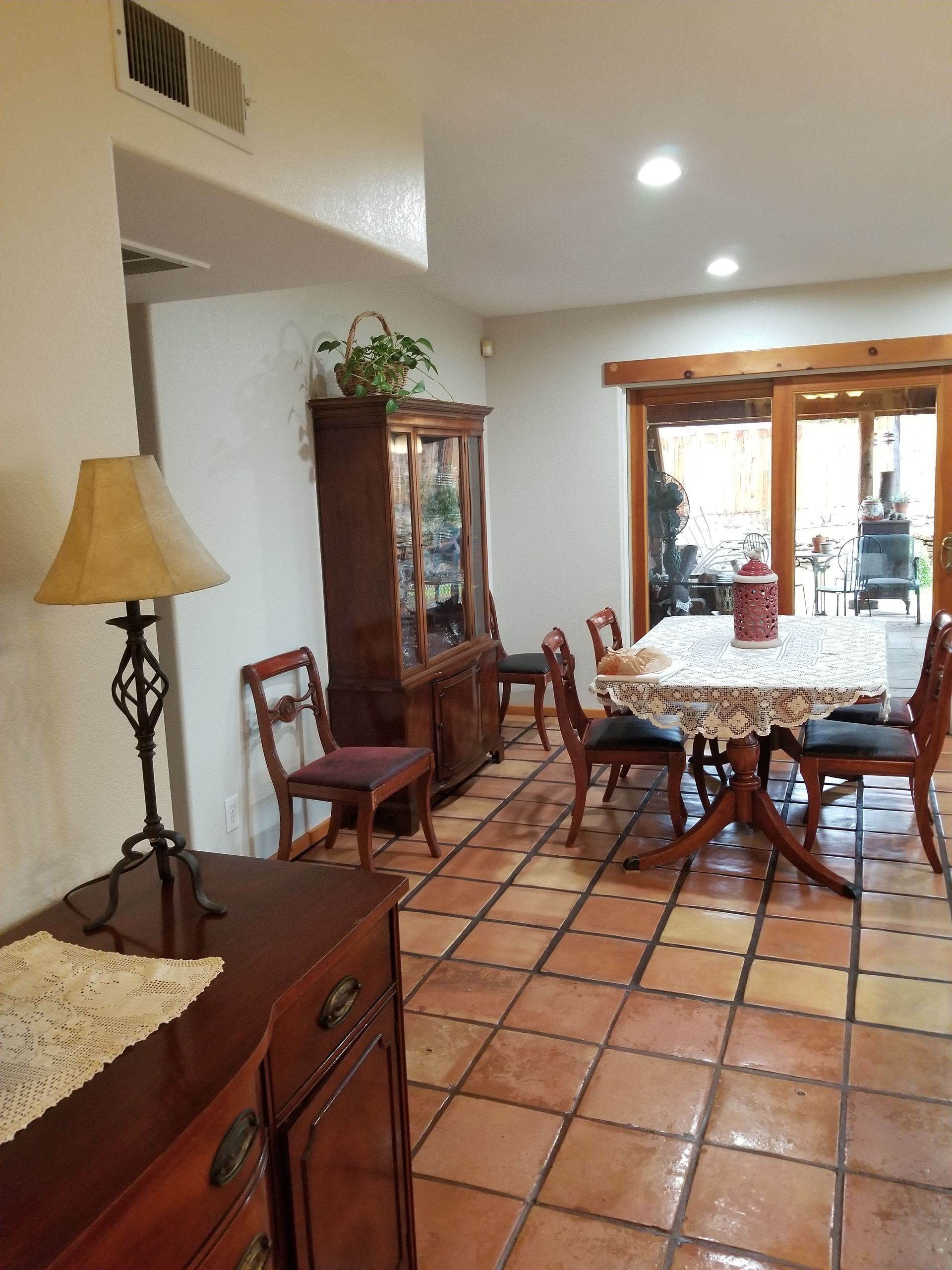 A dining room with a table and chairs and a lamp