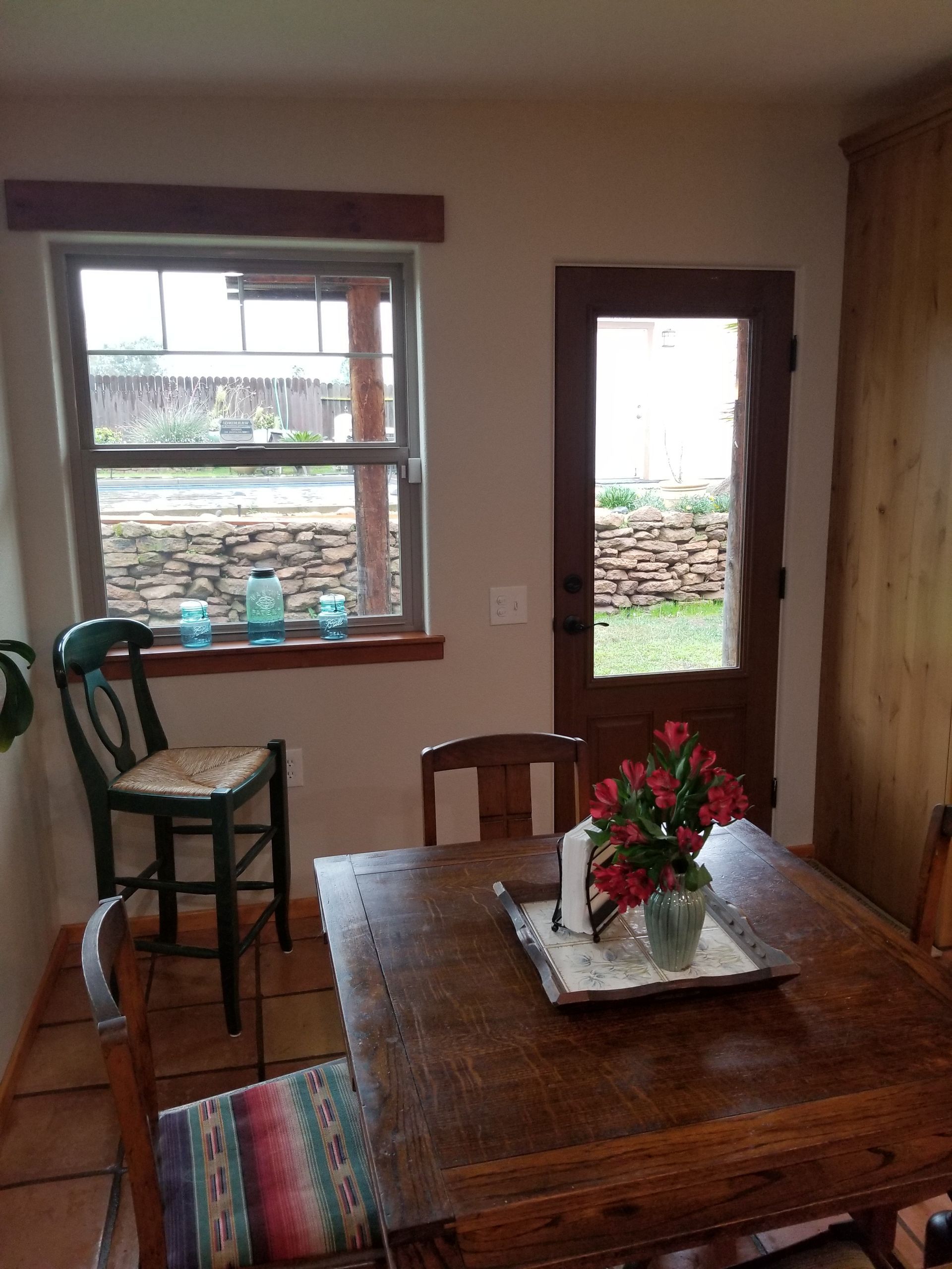 A dining room table with a vase of flowers on it.