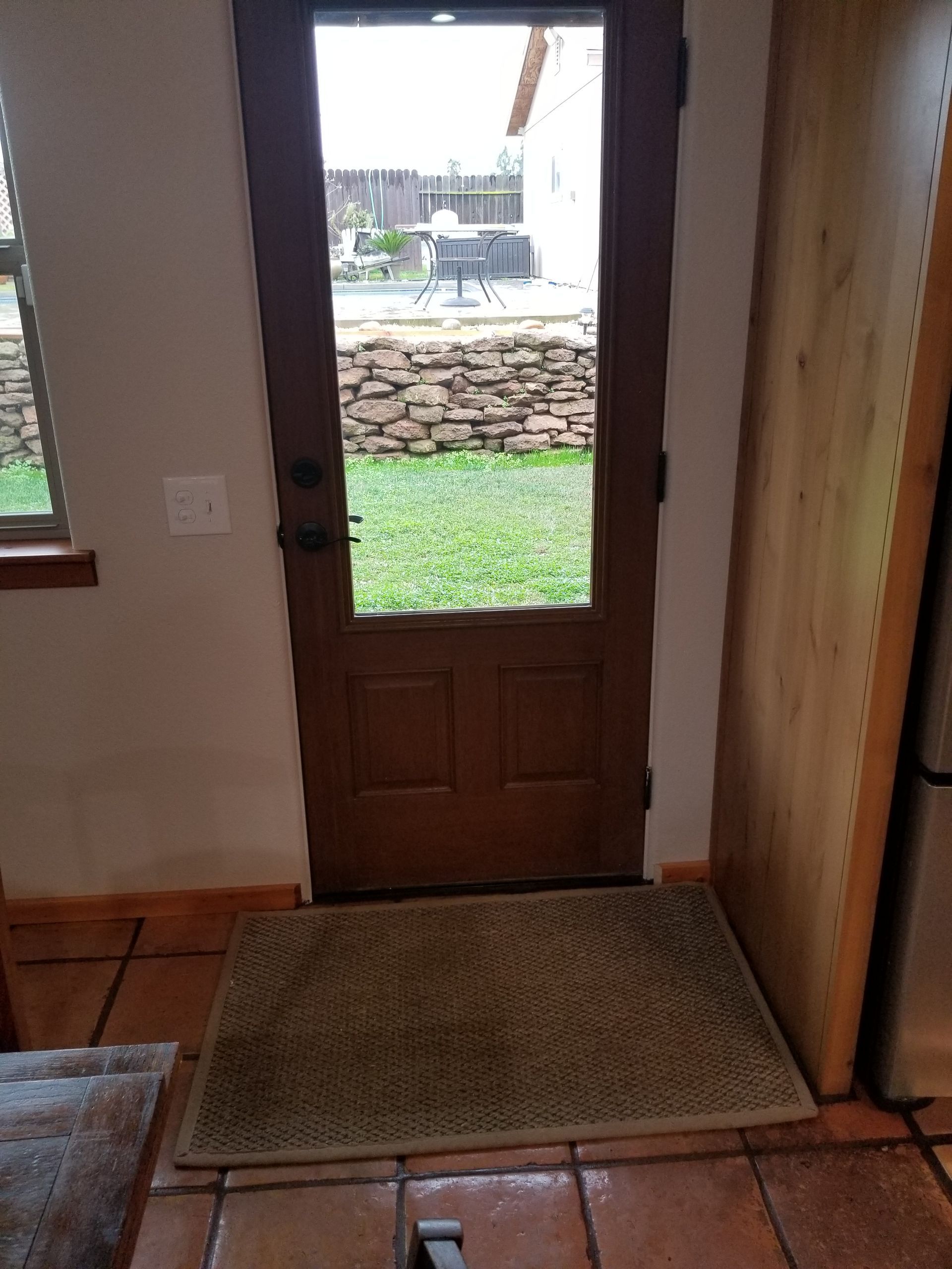 A door with a window and a rug on the floor