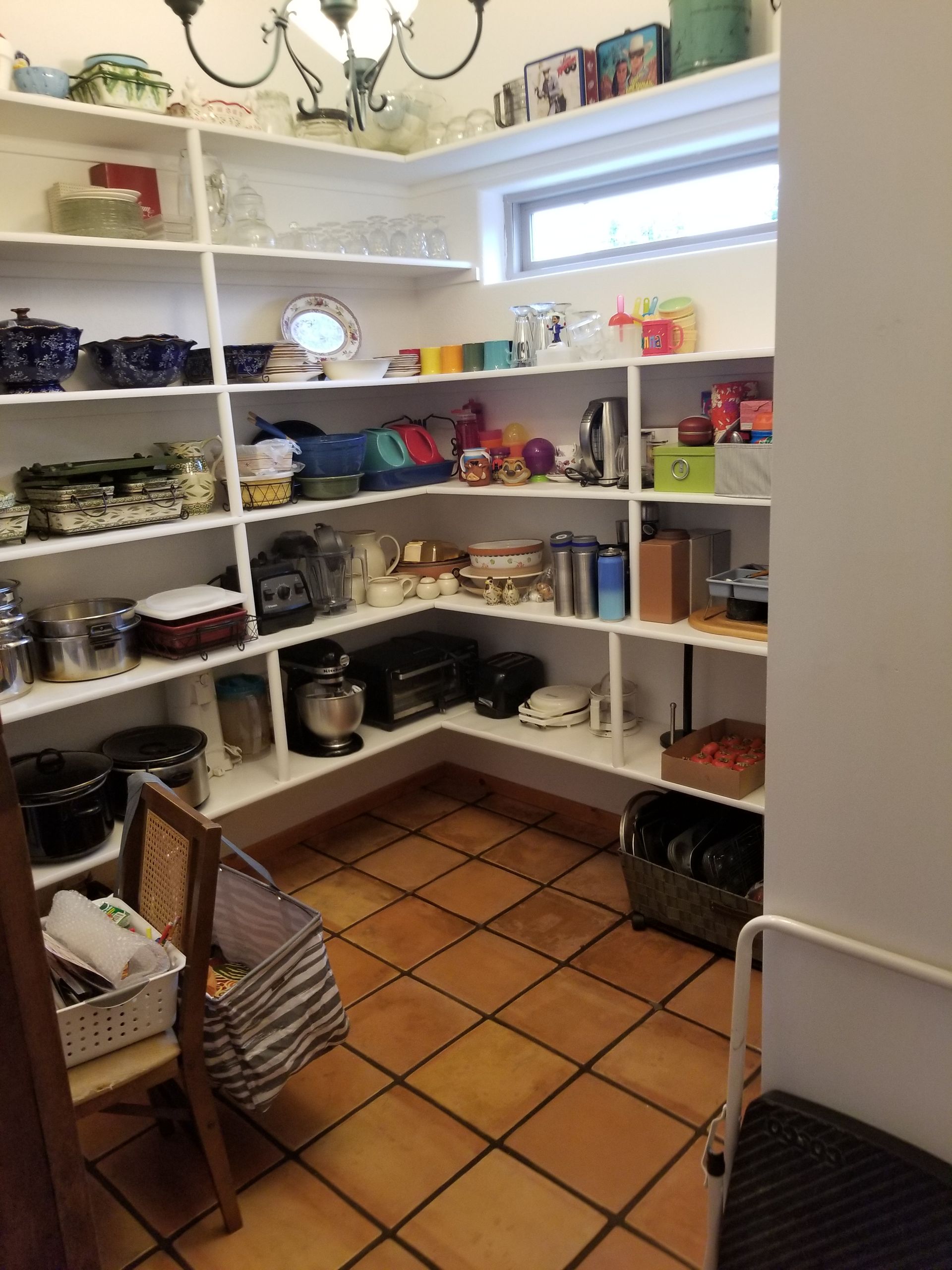 A pantry filled with lots of items and a chair