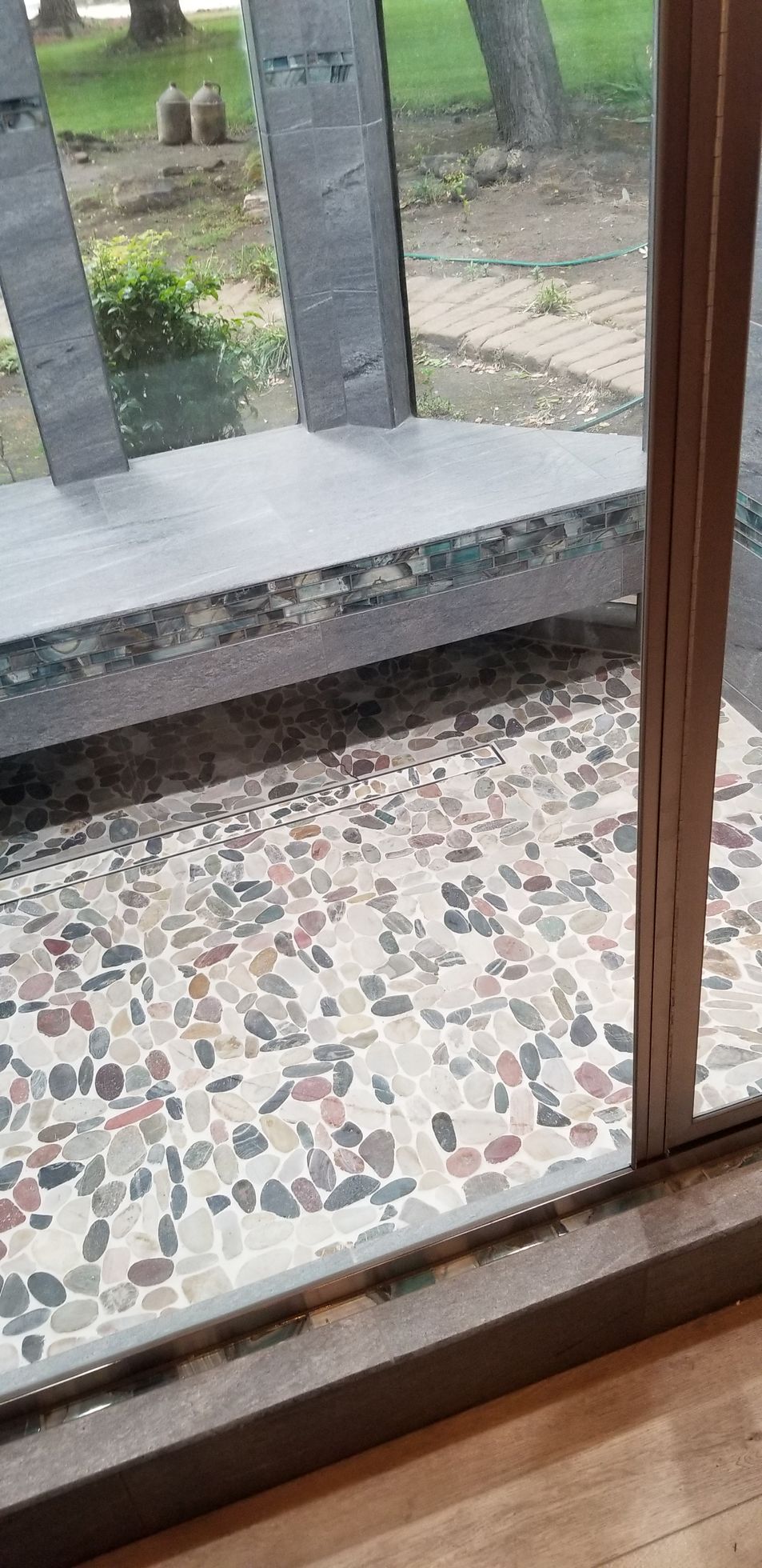 A sliding glass door with a bench in the background.