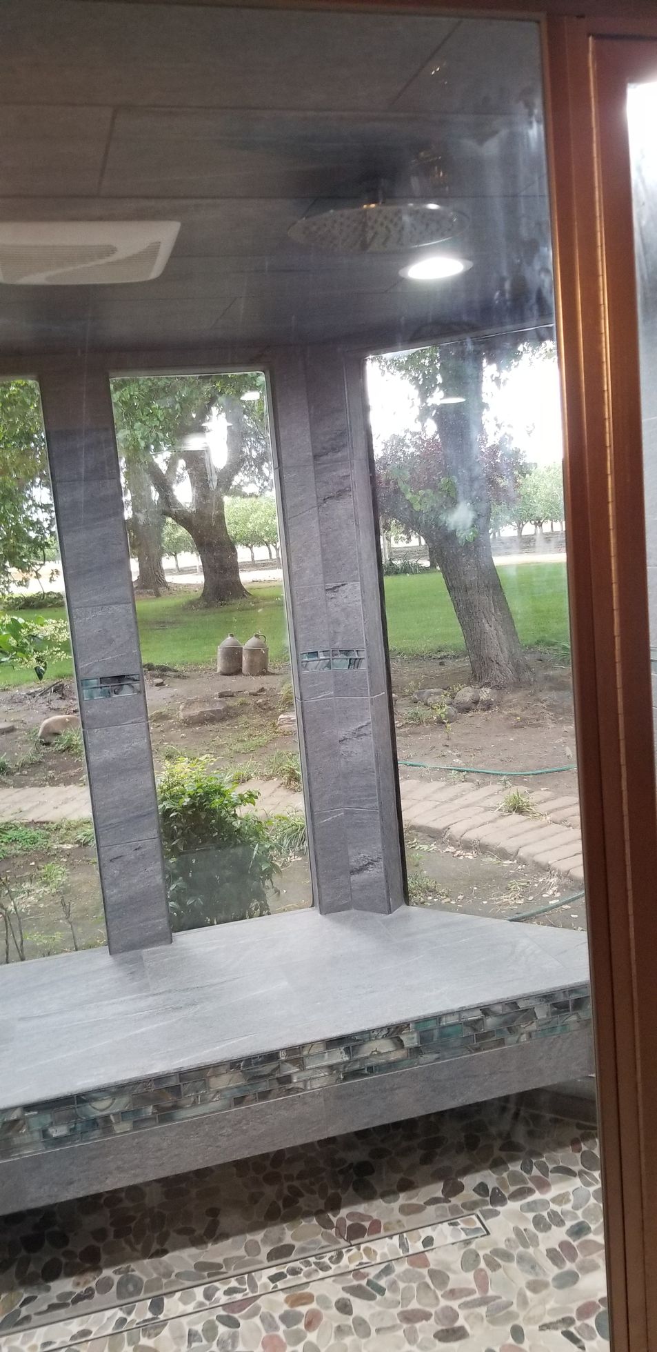 A view of a park through a window with trees in the background.