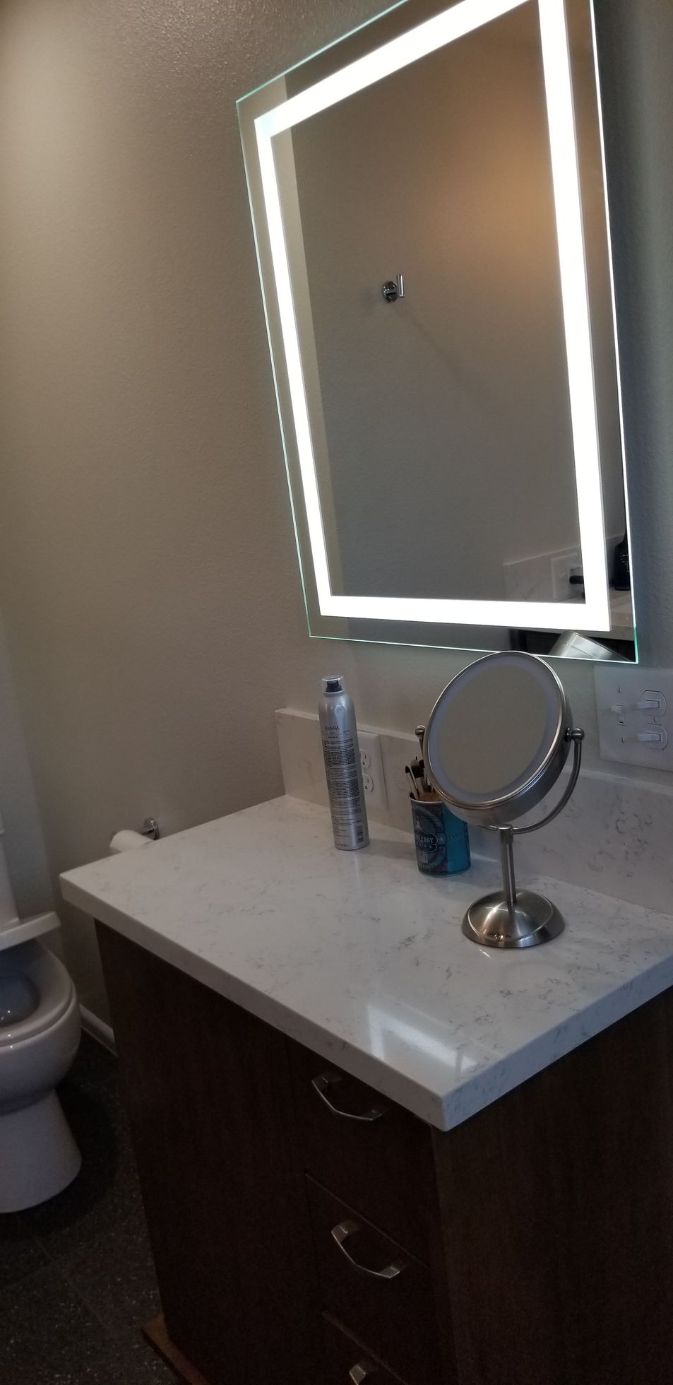 A bathroom with a sink , mirror and toilet.