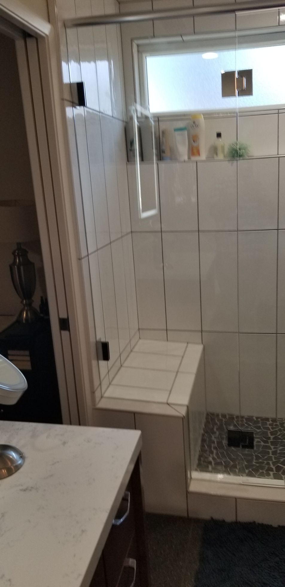 A bathroom with a walk in shower and a sink.
