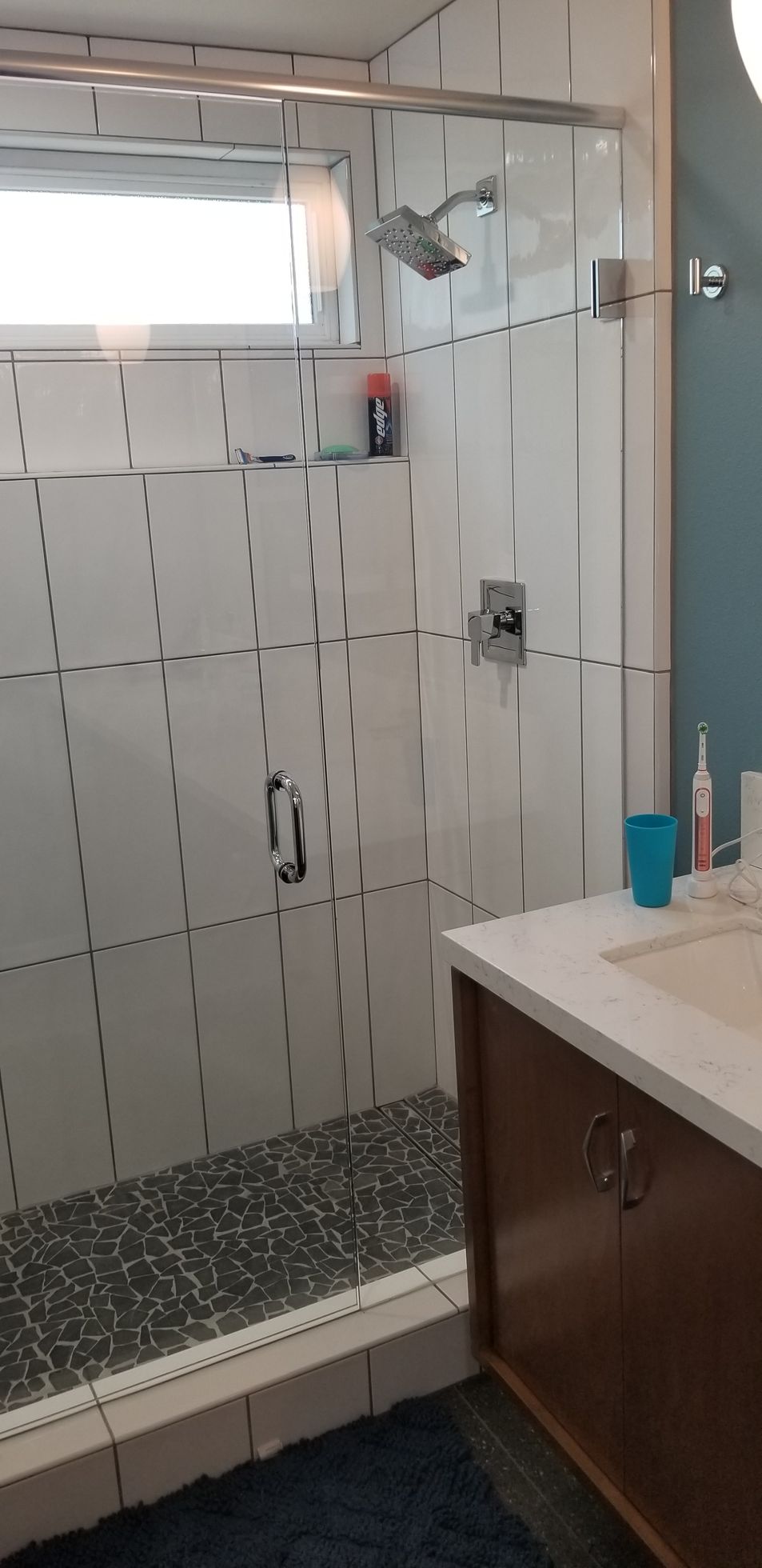 A bathroom with a walk in shower and a sink.