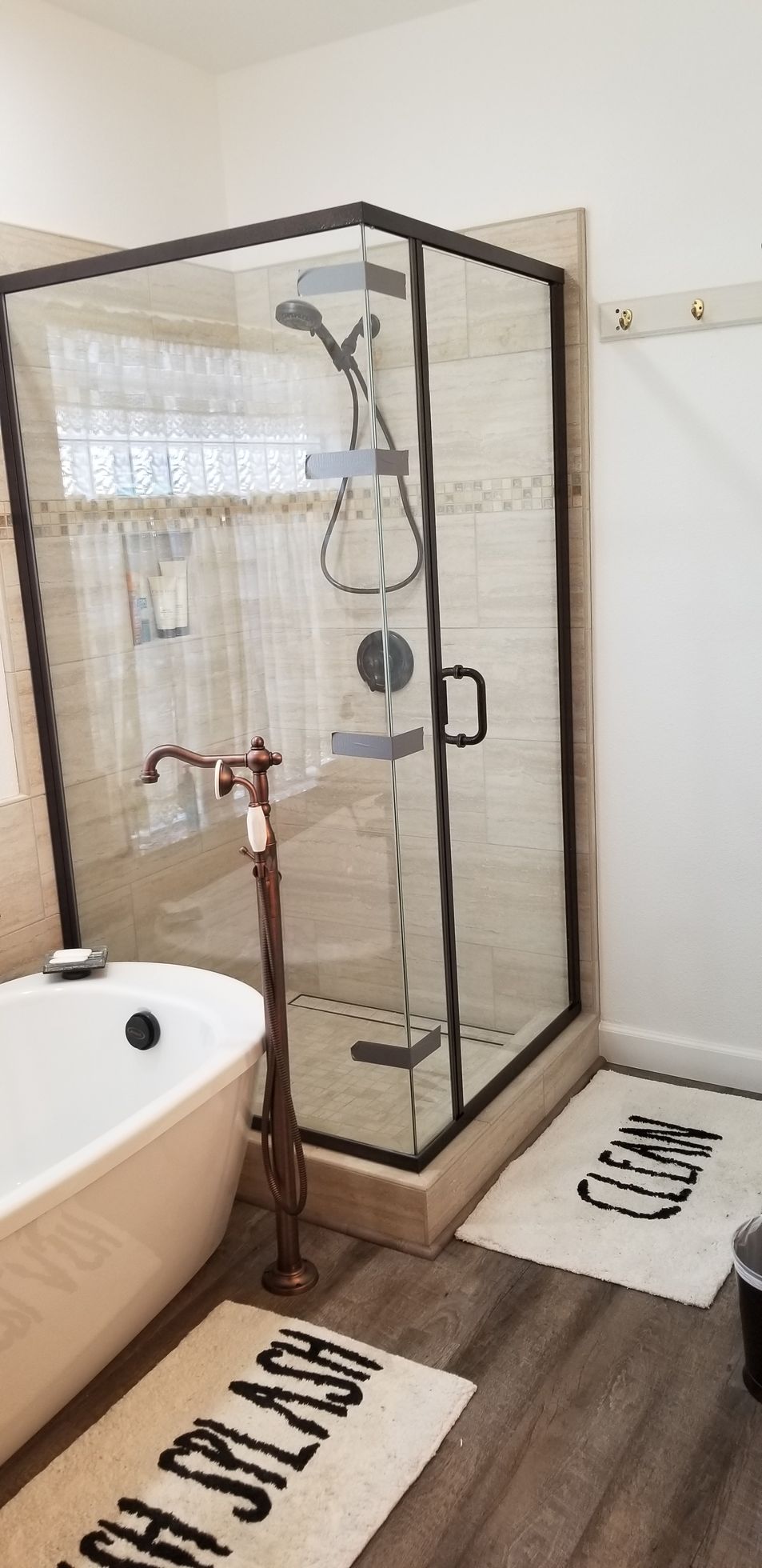 A bathroom with a bathtub , shower , and rug.
