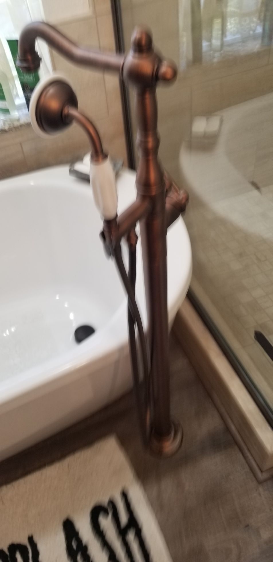 A bathroom with a bathtub and a faucet with a shower head attached to it.